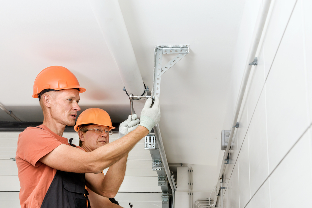 The,workers,are,installing,lift,gates,in,the,garage.